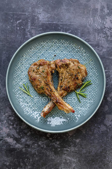 Roasted Lamb chops with rosemary on blue plate — Stock Photo