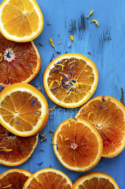 Blutorangen, Orangen und essbare Blütenblätter — Stockfoto