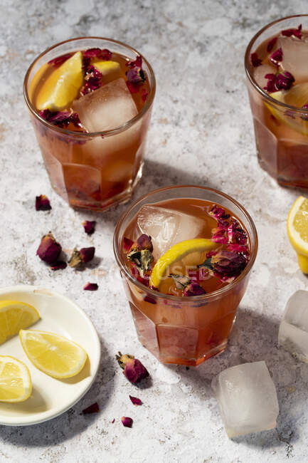 Lemonade made of rose syrup with lemon juice, ice cubes, rose petals and dried rose flowers — Stock Photo