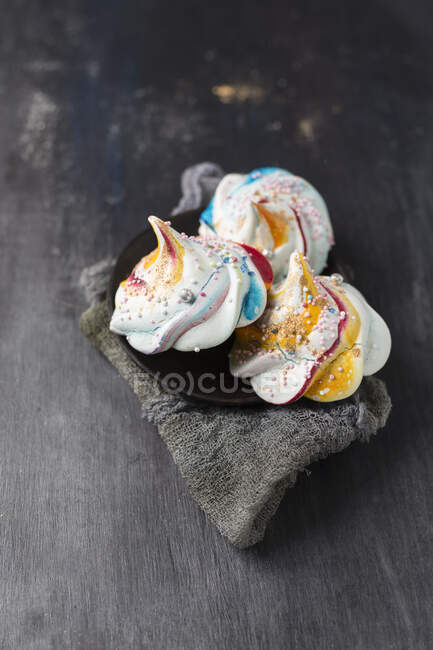 Merengues arremolinados de colores con perlas de azúcar - foto de stock