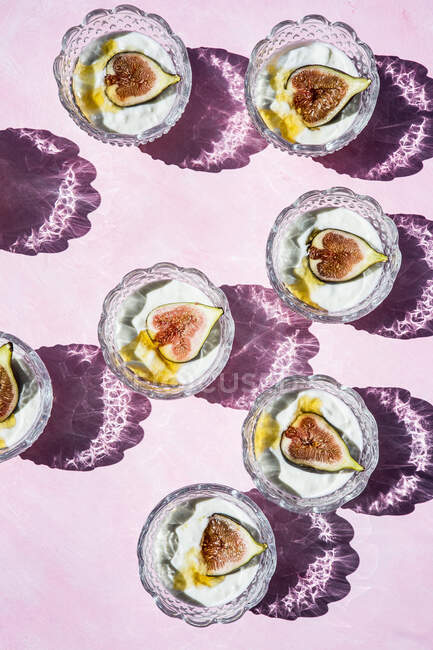 Yogurt with figs and honey in crystal glasses — Stock Photo
