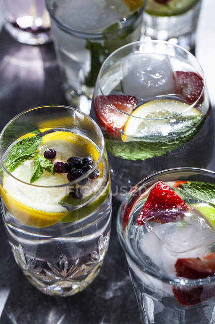 Various glasses of water filled with fruit, mint and ginger — Stock Photo