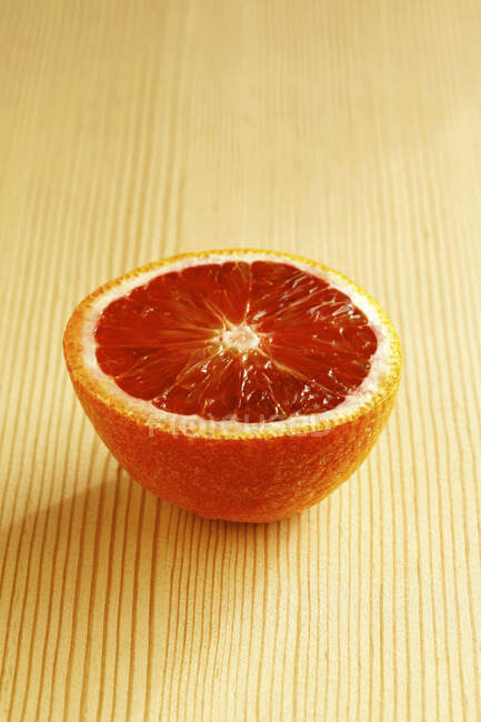 Mezza arancia rossa su sfondo chiaro — Foto stock