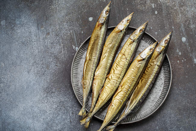 Smoked saury on a metal plate top view — Stock Photo