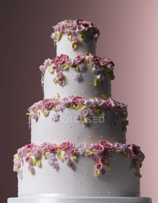 Easter Celebrations, tiered white wedding cake with tumbling sugared flowers — Stock Photo