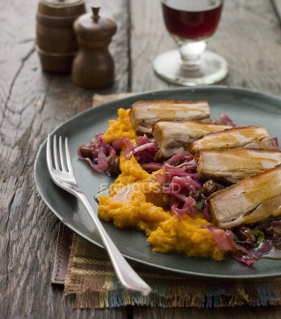 Pork belly on bed of sweet potatoes mash and red cabbage — Stock Photo