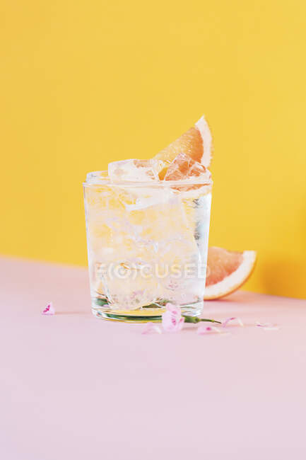 Gin and tonic with grapefruit slices and flowers — Stock Photo