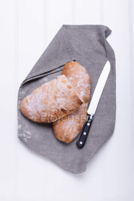 Ciabatta sur serviette en tissu avec couteau — Photo de stock