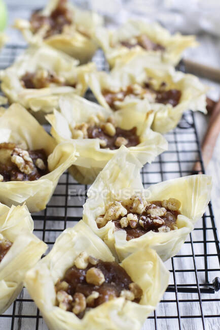 Mini apple pies with phyllo crust cooling on a bakers rack — Stock Photo