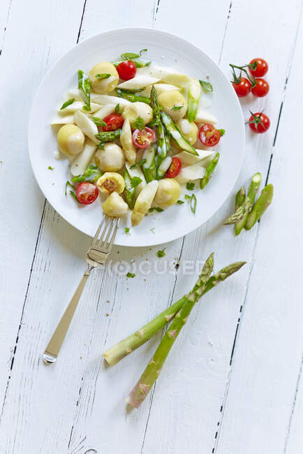 Filled mini dumplings with asparagus ragout and cherry tomatoes — Stock Photo