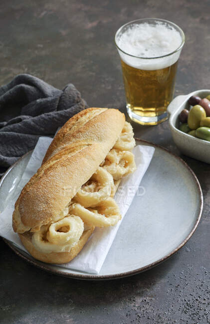 Sandwich con anelli di calamaro sul piatto con tovagliolo — Foto stock