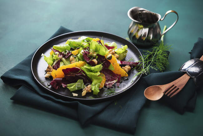 Salat, Radicchio und Orangenfilets mit Orangen-Dill-Dressing, karamellisierten Walnüssen und Kürbiskernen — Stockfoto