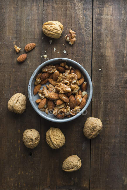 Walnuts and almonds in a ceramic bowl — Stock Photo
