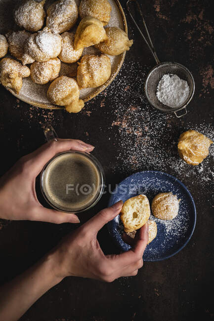 Mini donuts with powdered sugar and a cup of coffee — Stock Photo