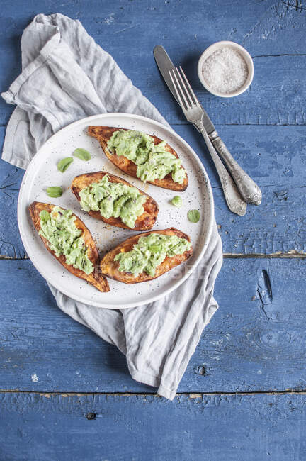 Baked sweet potatoes stuffed with guacamole and sprinkled with fresh mint — Stock Photo