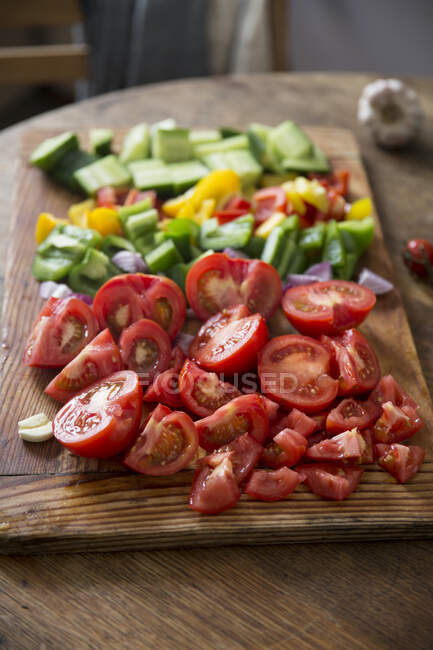 Chopped gazpacho vegetables on a wooden board — Stock Photo
