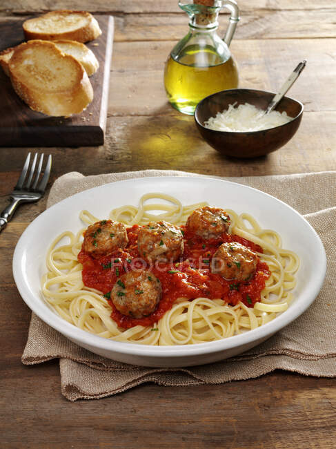 Italian meatballs in tomato sauce on a bed of linguine noodles — Stock Photo