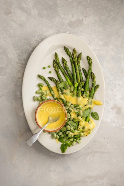 Asparagus, broad beans and peas with hollandaise sauce - foto de stock