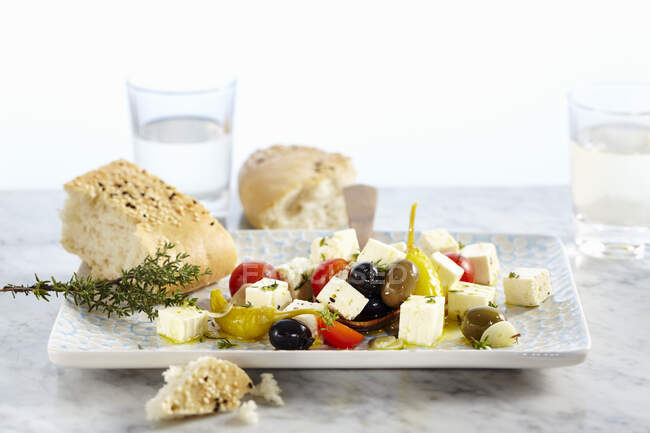 Feta-Käse in Olivenöl mit Tomaten, Knoblauch, Jalapeños und Oliven, serviert mit ungesäuertem Sesambrot — Stockfoto