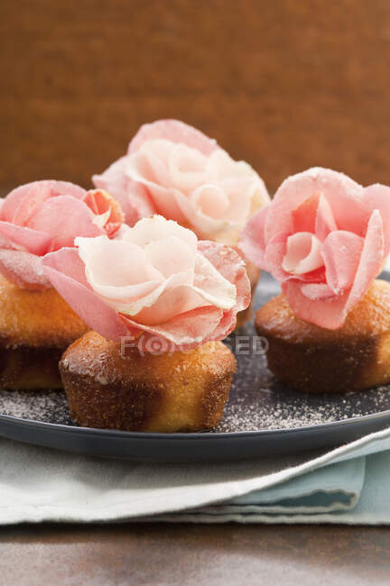 Міні кекси прикрашені рожевими цукровими квітами — стокове фото