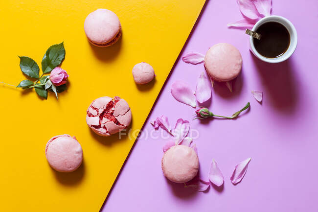 Розовые макароны с розовыми цветами и чашкой кофе — стоковое фото