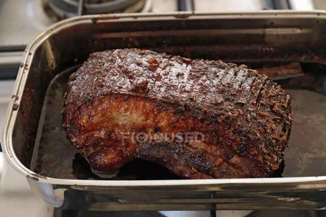 Roasted pork belly with oil in metal tin — Stock Photo