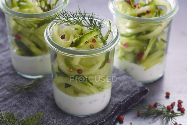 Cucumber spaghetti with pink pepper and dill in glasses — Stock Photo