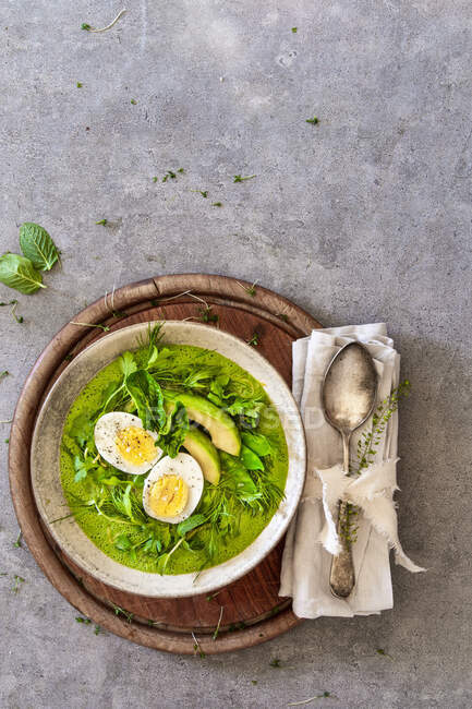 A smoothie bowl with boiled egg, avocado and mange tout in a nest of herbs — Stock Photo