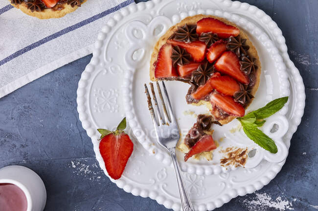 Mini tart with strawberry jam, served with fresh strawberries and chocolate ganache — Stock Photo