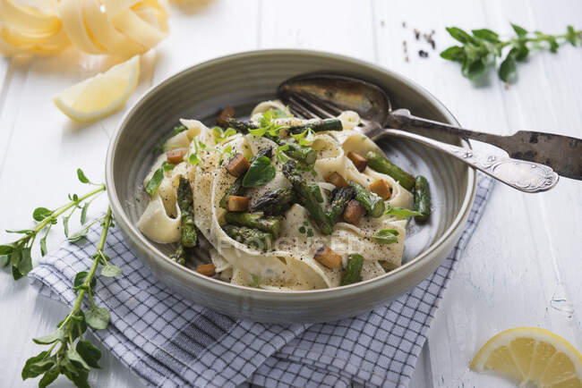 Tagliatelle in cashew nuts cream with grilled green asparagus and smoked tofu — Stock Photo