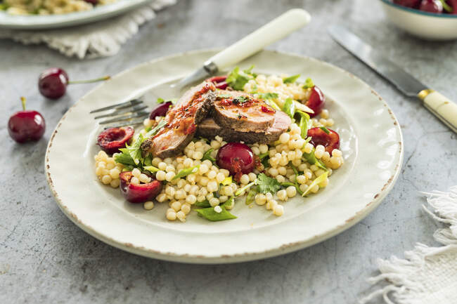 Couscous-Salat mit frischen Süßkirschen und gebratener Entenbrust — Stockfoto