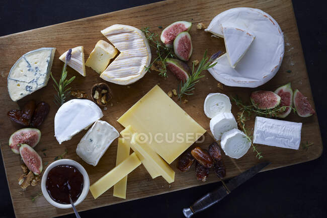 Cheese platter with figs, dates and walnuts — Stock Photo