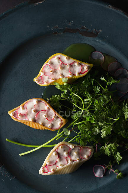 Conchiglioni Arlecchino filled with ricotta and radishes in a herb sauce — Stock Photo