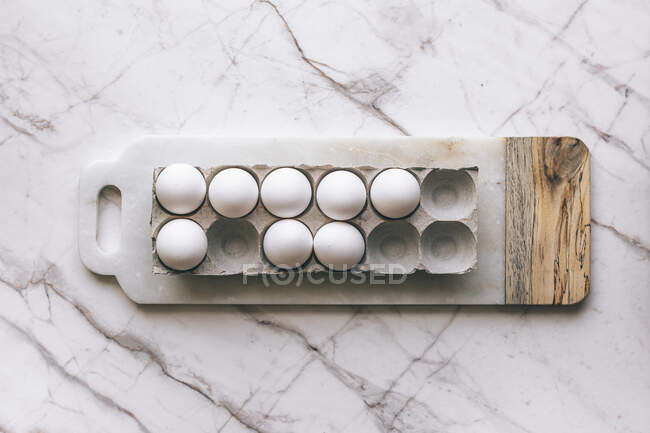 Білі яйця на мармуровій поверхні — стокове фото