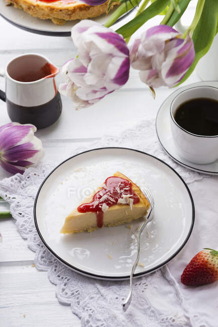 Vegan cheesecake with strawberry sauce and white, grated rice milk chocolate — Stock Photo