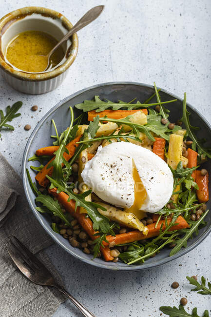 Roasted vegetables salad with lentils - carrots, parsnip and celeriac, rocket, lentils and poached egg — Stock Photo