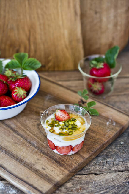 Yogurt with strawberries, pistachios and maple syrup — Stock Photo