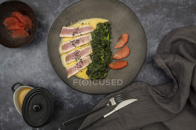 Tuna with grapefruit pulp and spinach on plate — Stock Photo