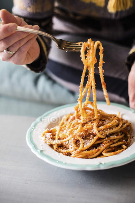 A person eating spaghetti with tomato sauce — Stock Photo