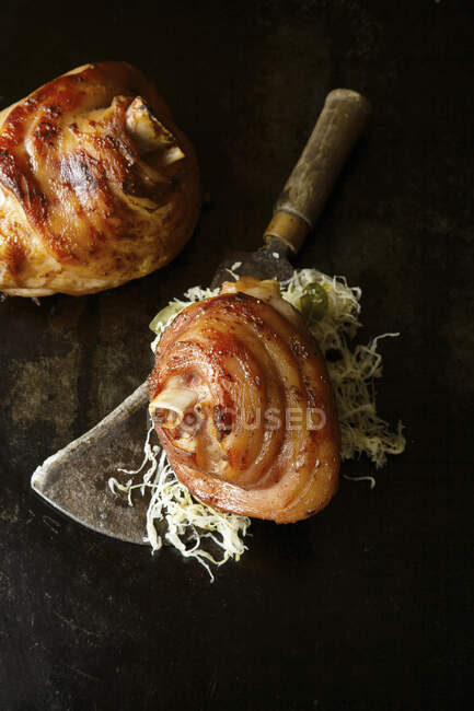 Grilled pork knuckles with sauerkraut on a meat cleaver — Stock Photo