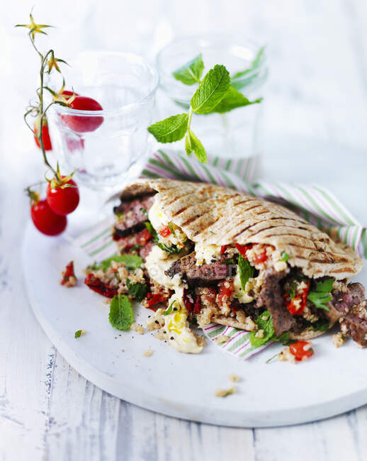 Pain plat Pitta avec agneau, menthe, quinoa, houmous et poivrons rouges — Photo de stock
