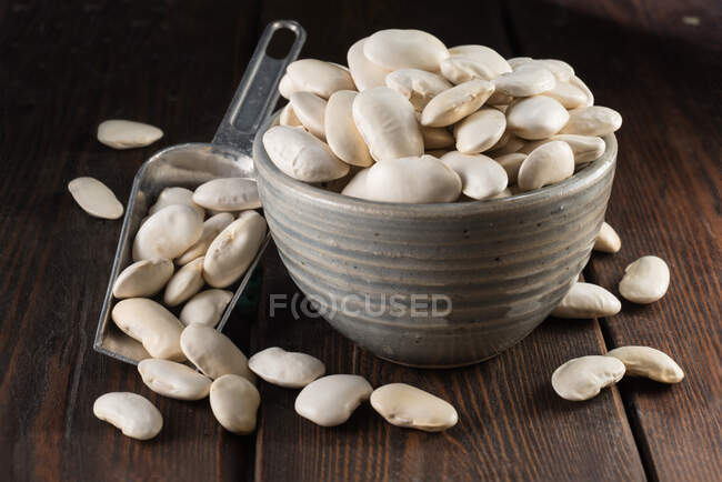 Feijão espanhol branco seco em uma xícara de cerâmica — Fotografia de Stock