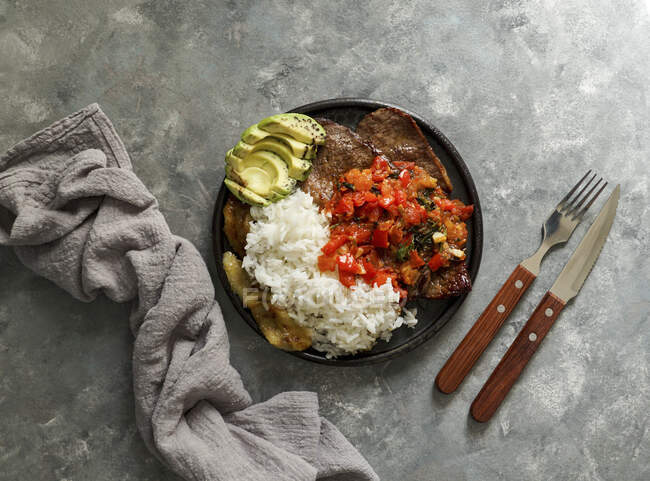 El Bistec a la Criolla - Colombian beef steak with tomatoes sauce, rice, avocado, bananas fries — Stock Photo