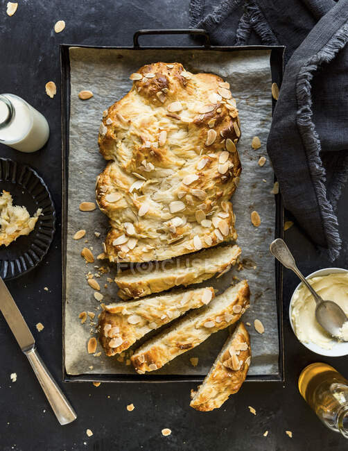 Yeast bread with almond flakes in baking tin — Stock Photo