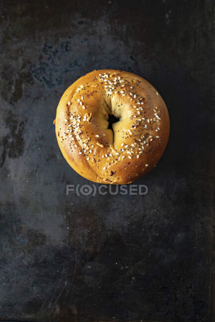 A sesame seed bagel on a baking tray — Stock Photo