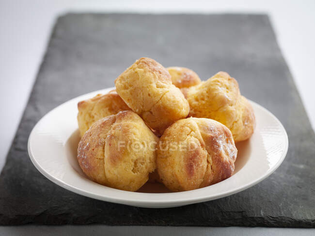 Freshly baked profiteroles on a plate — Stock Photo