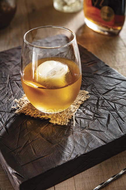 Vermouth and bourbon cocktail with ice cube in glass — Stock Photo