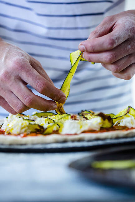 Preparação de pizza com courgette, queijo mussarela e molho de tomate — Fotografia de Stock