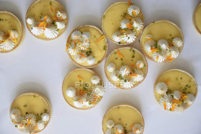 Zitronen- und Passionsfruchtkuchen mit Baiser-Punkten und Blütenblättern — Stockfoto
