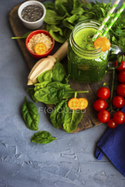 Зеленый коктейль из яблока, детского шпината, огурца, семян цыплят на бетонном фоне — стоковое фото